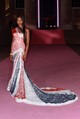 Naomi Campbell lélegzetelállító, testhezálló Givenchy-ruhában érkezett, amely a 2000-es őszi/téli Couture kollekció egyik archív darabja. A brit zászló színeiben pompázó csipkeruha aszimmetrikus vállmegoldásával és drámai uszályával tökéletesen egyesíti a klasszikus couture eleganciát a modern, ikonikus megjelenéssel.