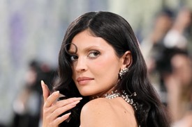 A smink a ruha kiterjesztése volt, és pontosan azt az esztétikát követte, amelyet Kylie Jenner annyira imád. A szőkített szemöldök volt a hab a tortán. A lágyan omló, precízen megalkotott fekete hullámok pedig finoman megtörték a bézs dominanciáját.