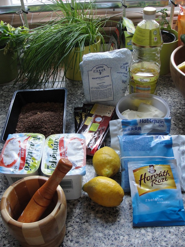 A túrórudi torta hozzávalói. A zabfalatokat már összetörtem a mozsárban, a csokit lereszeltem, ez látható abban a fekete műanyag tálban.