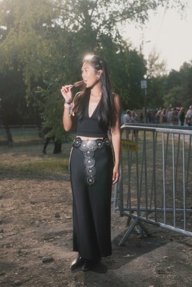 Ez az összeállítás igazi dark fesztivál hangulatot sugároz. A mélyen dekoltált top és a maxi szoknya kombinációja egyszerre kényelmes és stílusos. Saját csavart adott a megjelenéshez azzal, hogy egy feltűnő övet választott kiegészítőnek. A western csizma pedig tökéletesen hozza a gondtalan, nyári koncertélmény vibe-ját.