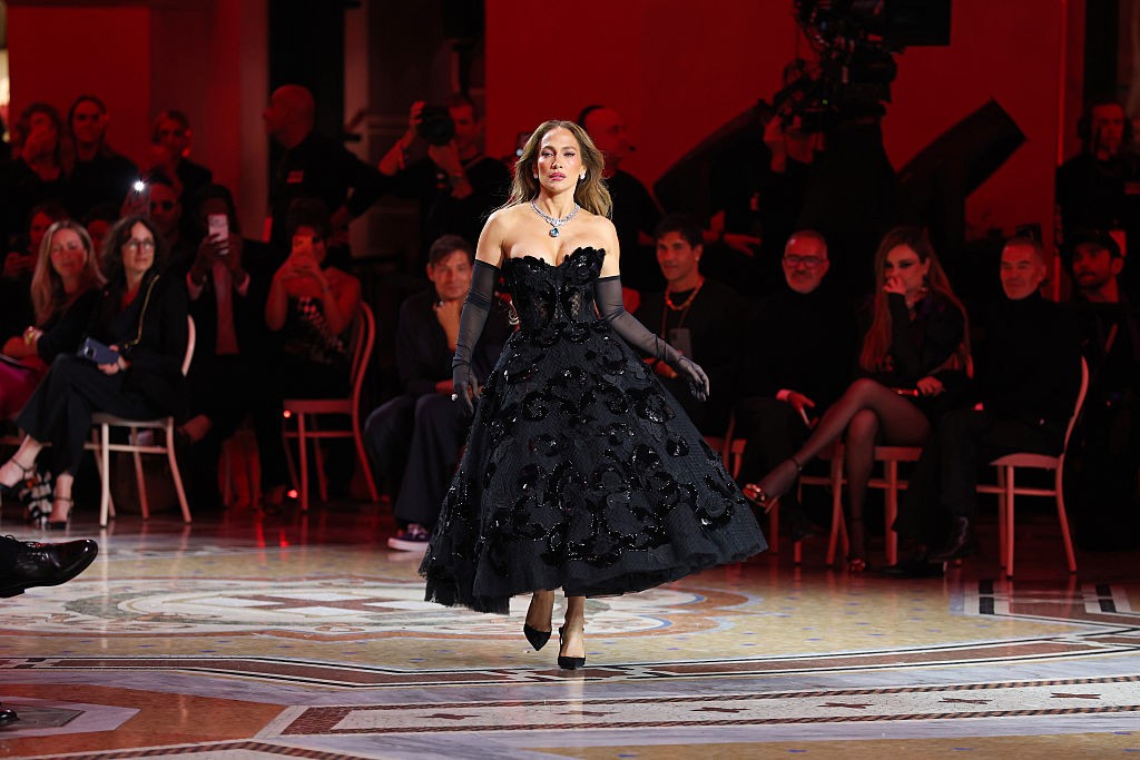 Jennifer Lopez az esemény egyik legnagyobb szenzációjaként érkezett egy éjfekete, monumentálisan terebélyes báliruhában. A Dolce & Gabbana kreáció tökéletesen ötvözte a klasszikus olasz drámaiságot a modern eleganciával.