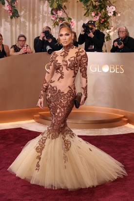 Ha valaki képes elegánsan viselni a költői túlzásokat, akkor az egyértelműen Jennifer Lopez, a meztelenruhák koronázatlan királynője. Jean-Louis Scherrer kreációja rengeteg áttetsző felülettel és kacér részlettel játszik, miközben sziluettjében is tovább emeli a tétet.
