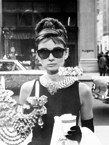  Audrey Hepburn Az álom luxuskivitelben című filmben minden idők egyik legismertebb, ikonikus napszemüvegét viselte. Az eredeti darab egy Manhattan névre keresztelt Oliver Goldsmith kreáció. A londoni márka a korszakban az első számú luxus szemüvegkeret, napszemüeg márkának számított.