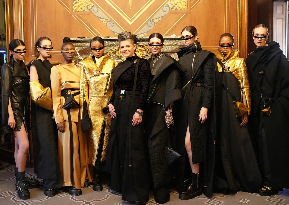 Fink Evelin magyar divattervező a modelljeivel a 2025/26-os EVELINFINK SOLAR kollekció párizsi bemutatójának backstage-ében – a La Galerie Bourbon falai között mutatta be futurisztikus, fekete-arany darabjait a Paris Fashion Week hivatalos programsorozatában Fotó: Olena Trvorcha