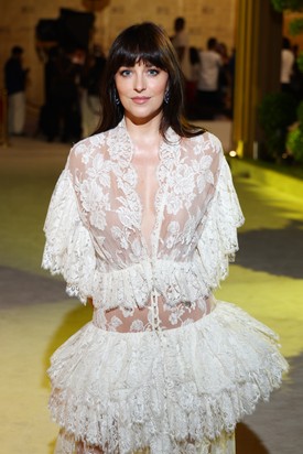 Dakota Johnson a Vörös-tengeri Nemzetközi Filmfesztivál vörös szőnyegére egy Chloé csipke meztelenruhában lépett, amelynek aprólékosan kidolgozott részletei, mint az áttetsző csipke a lábaknál és a hangsúlyos, mély dekoltázs, tökéletes egyensúlyt teremtettek a merészség és a kifinomultság között.