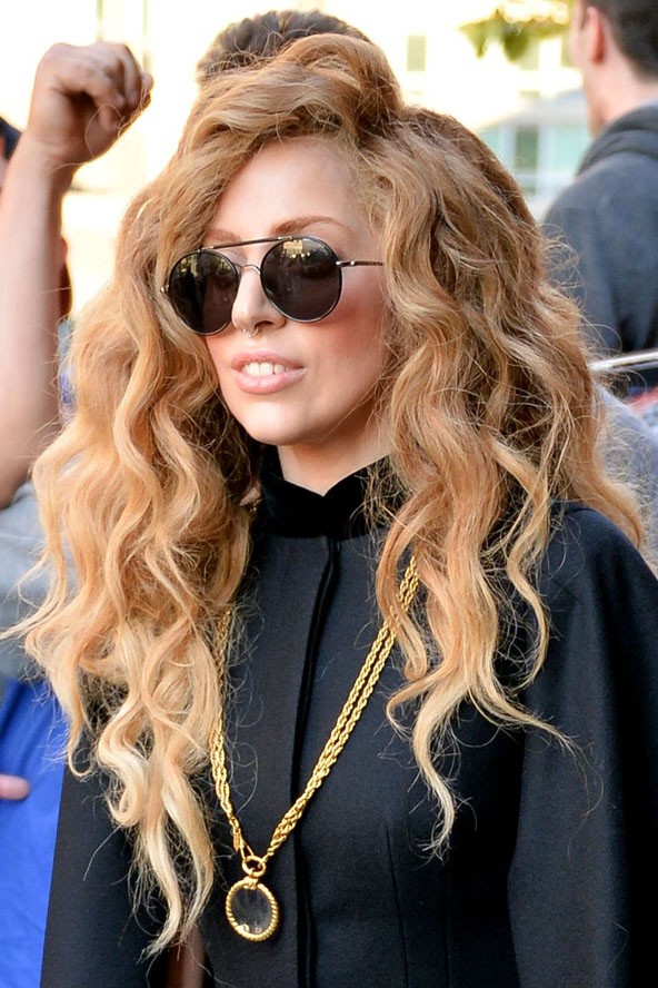 Igazi szivárvány gyermek ezzel a hosszú, göndör frizurával és a kerek napszemüveggel.