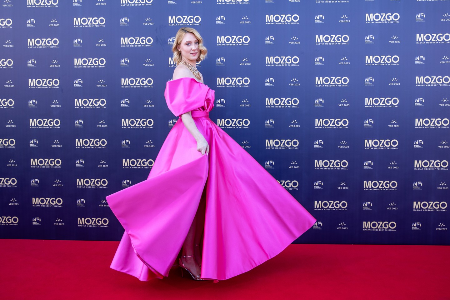 Rujder Vivien színésznő a Richard Demeter 2025-ös tavaszi-nyári kollekciójának fukszia, ejtett vállú, hosszú estélyi ruhájában ragyogott a Magyar Mozgókép Fesztivál díjátadó gálájának vörös szőnyegén