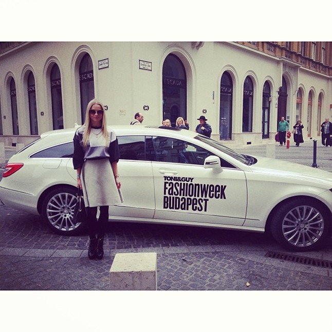 Iszak Eszti műorvezető a Toni&Guy Fashion Week Budapest hivatalos Mercedes Benz autója mellett pózol.
