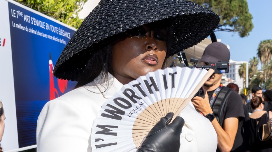 Yseult a Loréal híres mondatával a legyezőjén, Dior öltözékben a cannes-i filmfesztiválon