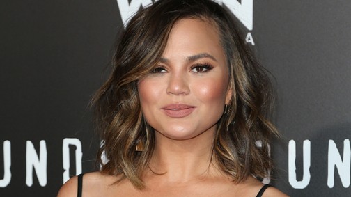 Videó! Chrissy Teigen megpróbálta betuszkolni a melleit a ruhába, nem sikerült