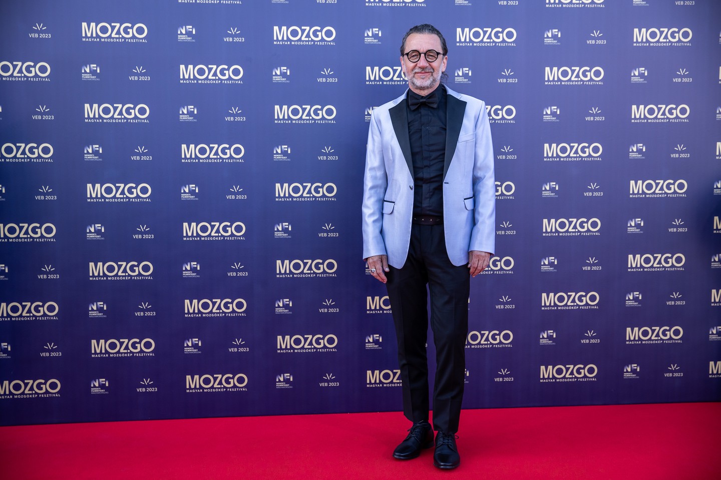 Csáky Attila fesztiváligazgató világos színű, ezüst selyem szállal szőtt, fekete selyem gallérral díszített Róbert Maar szmokingot viselt