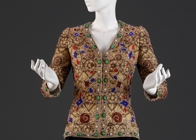 Rotschild Kla&#769;ra e&#769;kszerkardiga&#769;njait Yves Saint-Laurent egyik 1972-es modellje inspira&#769;lta. Bein Kla&#769;ra&#769;nak, a szalon ta&#769;rsadalmi ösztöndi&#769;jasa&#769;nak elbesze&#769;le&#769;se szerint Rotschild saja&#769;t pe&#769;nze&#769;n vett meg egy eredeti modellt, amiből ha&#769;rmat szerepeltetett a következő divatbemutato&#769;ja&#769;n. Mindha&#769;rom azonnal elkelt. Ma&#769;te&#769; Jola&#769;n, Joli ne&#769;ni volt az a magyar szakember, aki ke&#769;zimunka&#769;ban a francia Lesage-ha&#769;z minőse&#769;ge&#769;vel is ke&#769;pes volt felvenni a versenyt. Rotschild Kla&#769;ra nem egy az egyben ma&#769;solta Yves Saint-Laurent darabjait, hanem adapta&#769;lta azokat, e&#769;s a legva&#769;ltozatosabb remekeket gya&#769;rtotta hala&#769;la&#769;ig Jolika tuda&#769;sa&#769;ra e&#769;s fanta&#769;zia&#769;ja&#769;ra alapozva. Fotó: Kardos Judit