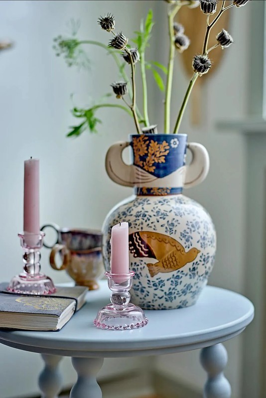 Vintage hangulat a nappaliban –  festett váza, finom rózsaszín gyertyák és könyvek, amelyek a grandmacore stílus bensőséges világát idézik