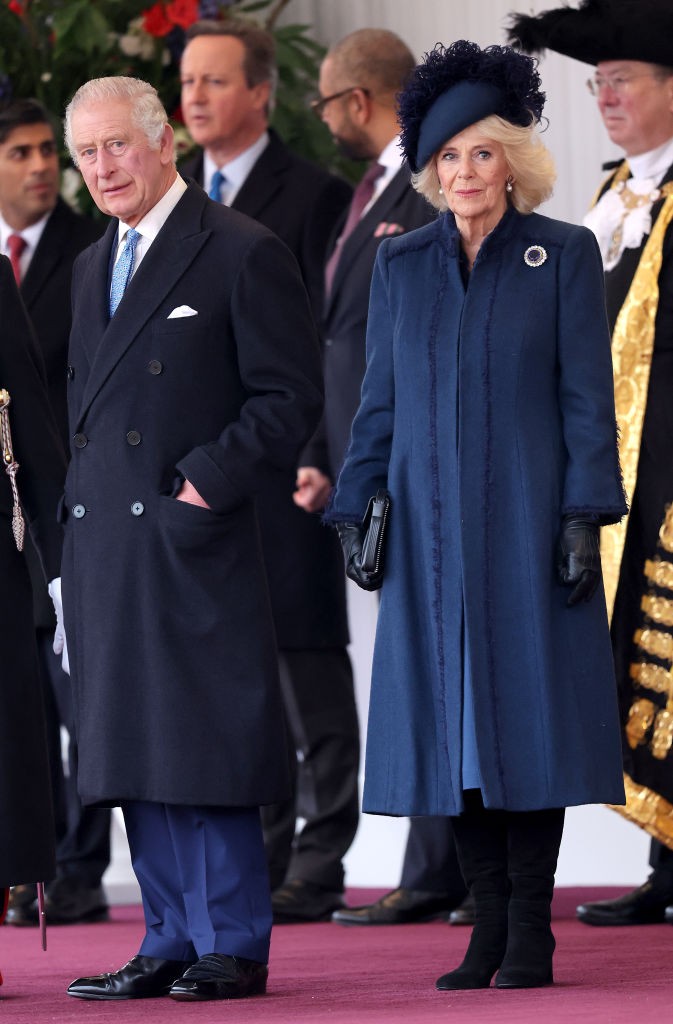 Kamilla királyné sötétkék kabátban és hozzá passzoló kalapban