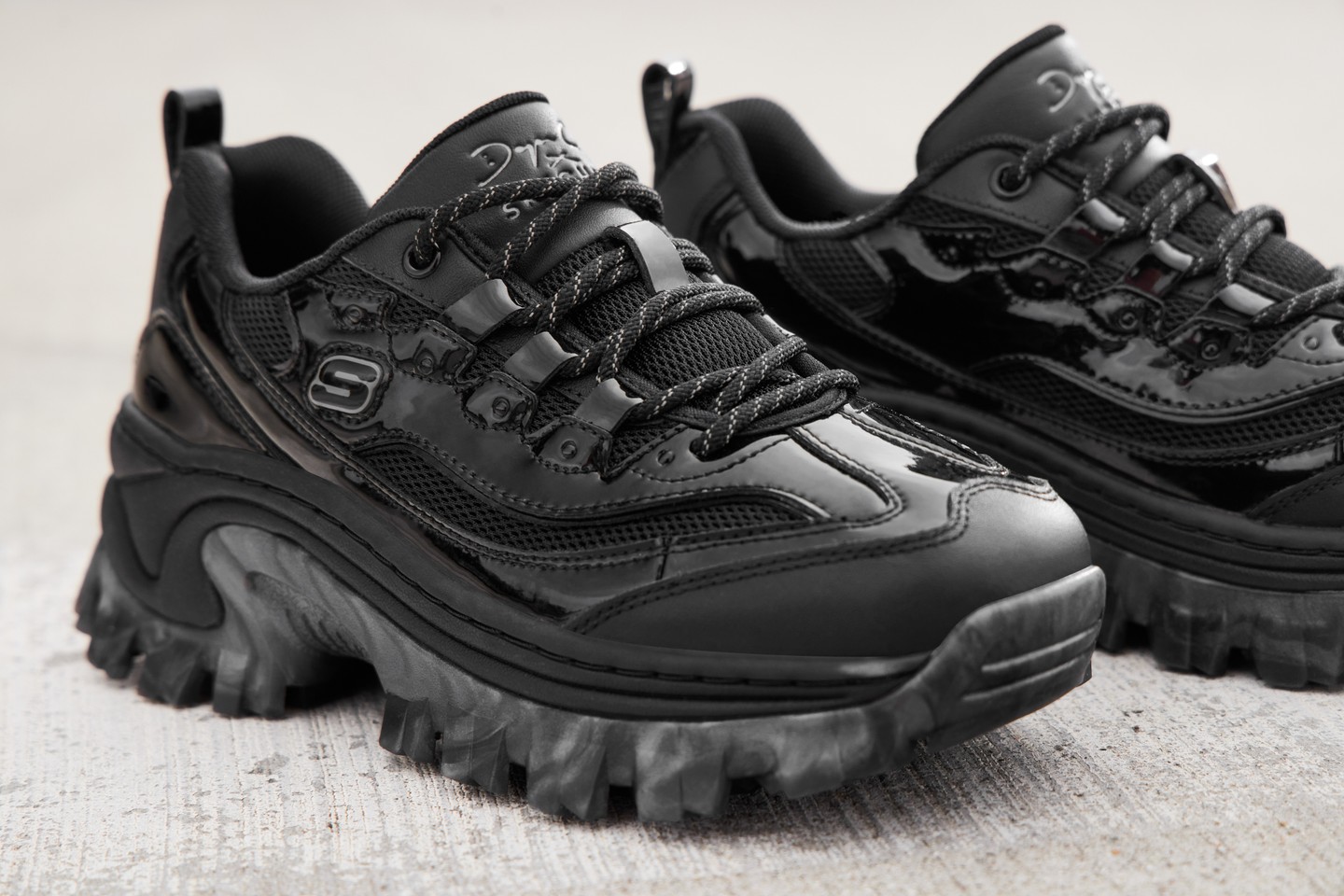 Ez a Doja'Lite fűzős cipő prémium lakkbőrrel, elegáns hálós felsőrésszel, valamint egyedi, fémes-márványos talppal érkezik.