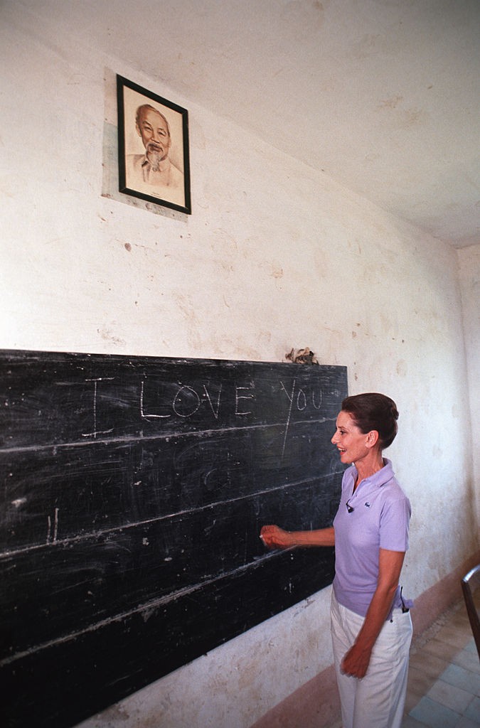 A világ egyik legnagyobb filmsztárja áll egy kopott táblánál, egyszerű lila pólóban, távol Hollywood csillogásától. Audrey Hepburn üzenete mégis világosabb minden reflektornál: „I love you” – írta a vietnámi iskolásoknak. 