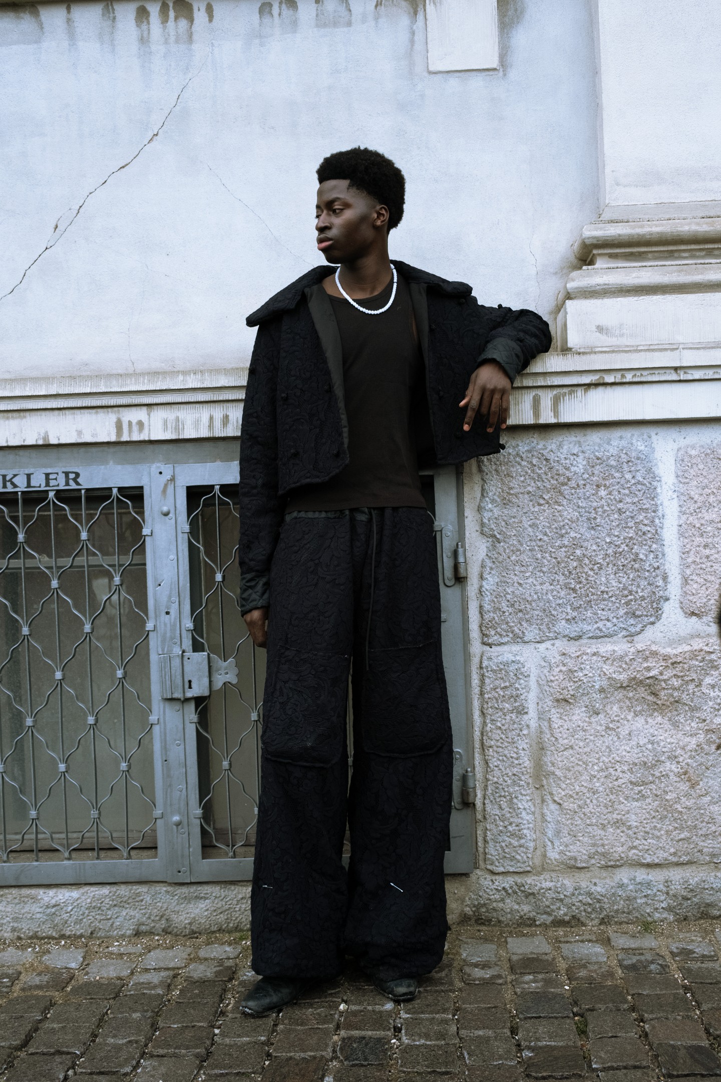 Sötét tónusok, egyetlen anyagcsaládra építve. A hangsúly a formán van, nem a részleteken, és ez teszi igazán erőssé ezt az összeállítást.