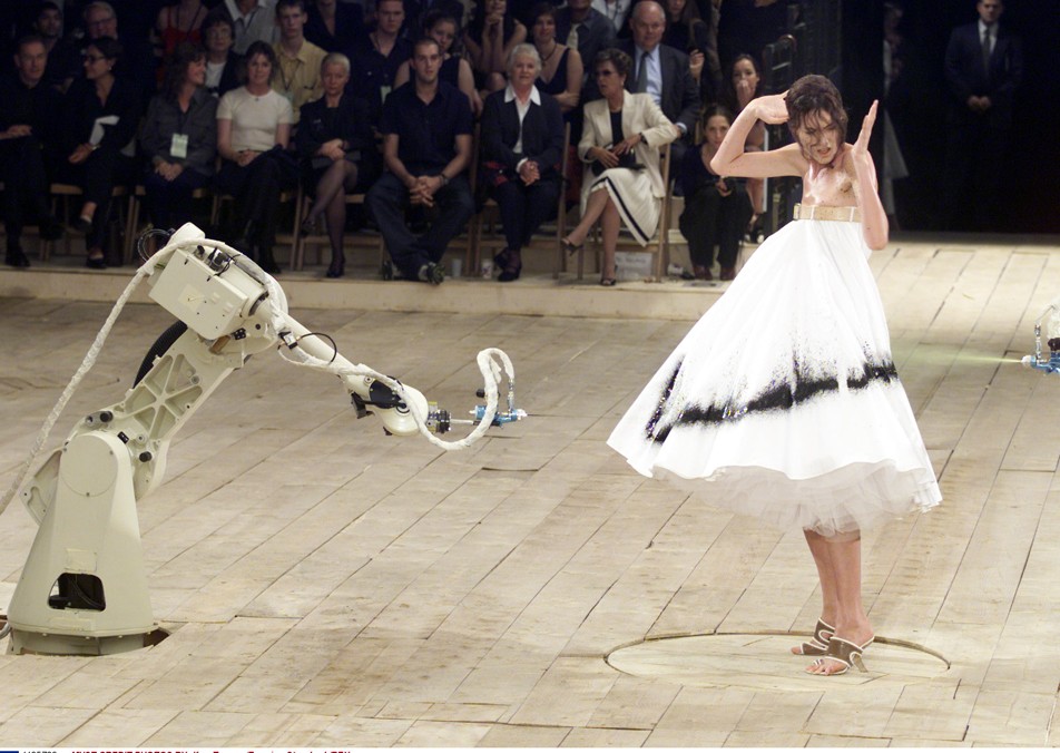 1999 tavaszára a No.13 nevű kollekcióban addig sosem látott ötletet vitt a kifutóra. Shalom Harlow hófehér ruhájára festékszóró robotok fújtak mintát élőben.