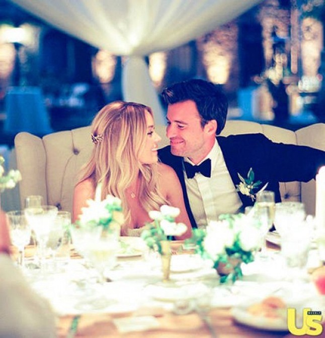 A jegyes pár egy nagy kétszemélyes fotelben ült az asztalnál.