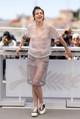 Kristen Stewart egy galléros, zsebekkel díszített átlátszó felsőben és hozzá passzoló, térdig érő szoknyában vonzotta magára a tekinteteket, amit egy laza, fekete-fehér sportcipővel egészített ki. És bár a Chanel outfit a meztelenség illúzióját keltette, testszínű bélésnek köszönhetően mégsem mutatott meg mindent a testéből.