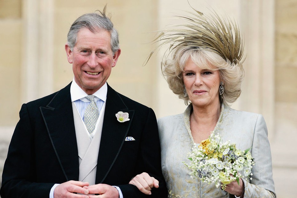 Károly walesi herceg és Camilla Parker Bowles, Cornwall hercegnéje Robinson Valentine selyemruhájában és Philip Treacy fejdíszében távozik a házasságukat megáldó ima és szentelési szertartásról a windsori kastélyban 2005. április 9-én az angliai Berkshire-ben