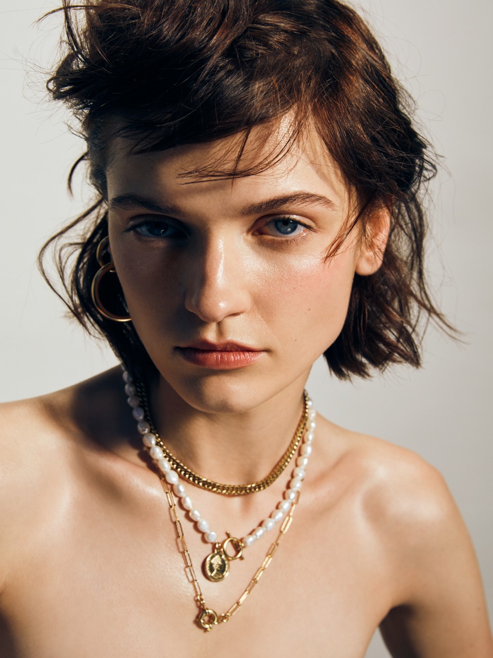 Rövid arany és gyöngyös nyaklánc medállal, karika fülbevaló: KULKA, Hosszú arany nyaklánc: WIOLA WOŁCZYŃSKA