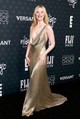 Elle Fanning egy extra mélyen dekoltált, arany, fémesen csillámló Ralph Lauren estélyiben lopta el a show-t. 