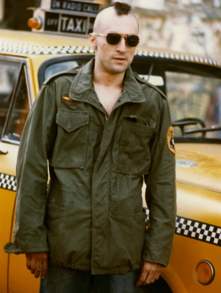 Robert De Niro Travis Bickle szerepében, a Taxisofőr (1976) forgatásán. A mohawk frizura, a katonai dzseki és a napszemüveg egy egész generáció filmes emlékezetébe égett bele. Ez a karakter hozta meg De Nirónak a világhírnevet.