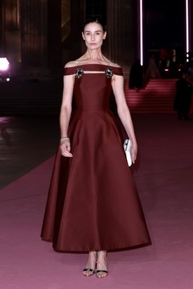 Erin O’Connor modell mélybordó Prada-ruhájában a minimalizmus és a drámaiság tökéletes egyensúlyát hozta. Klasszikus szabása és visszafogott, mégis határozott kisugárzása igazi példája a csendes luxusnak.