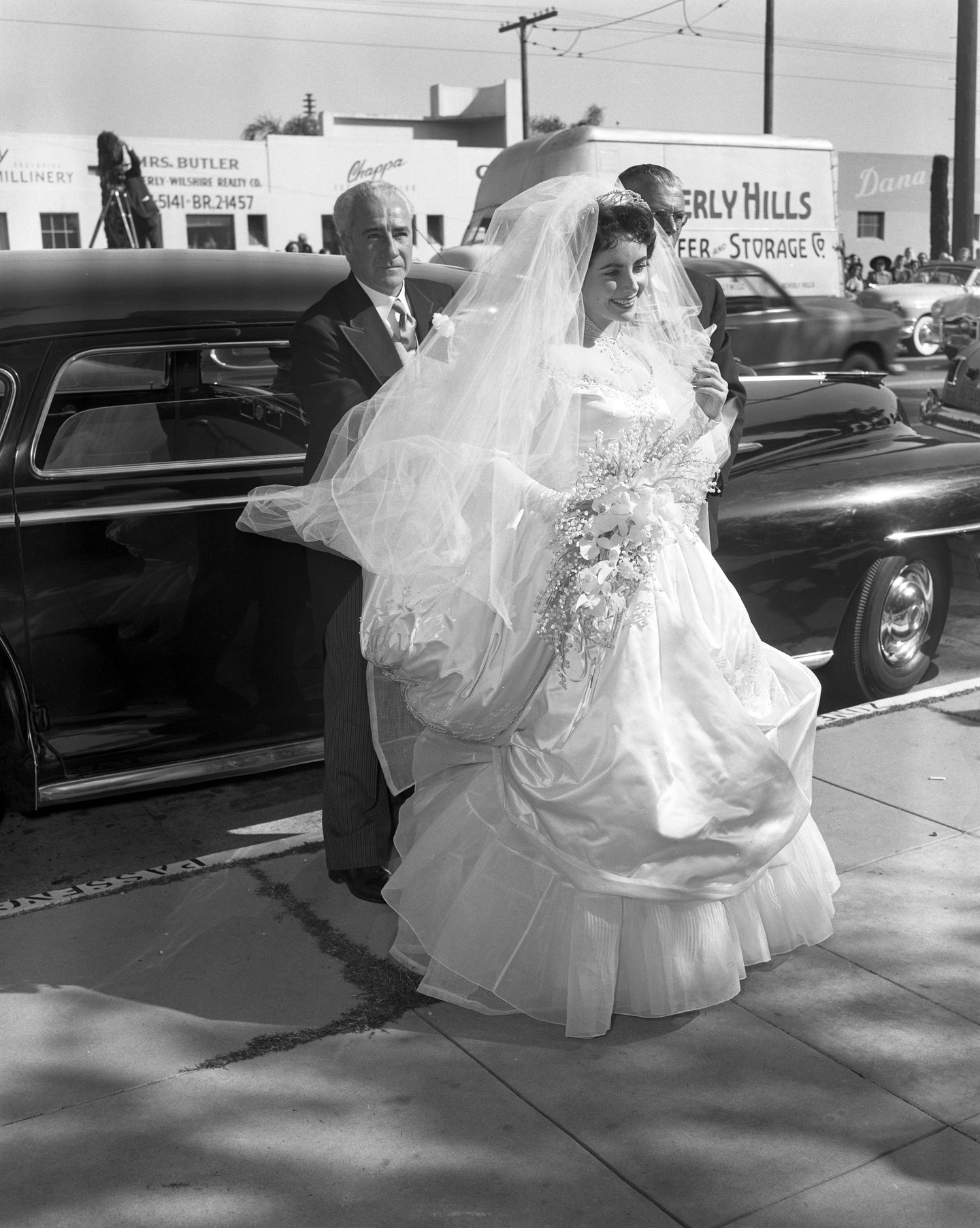 1950. május 6-án Elizabeth Taylor mindössze 18 éves volt, amikor apja oldalán megérkezett első esküvőjére. Bár a menyasszonyi ruha és a mosoly filmszerű volt, a házasság Conrad Hilton Jr.-ral mindössze nyolc hónapig tartott - a férfi már a nászúton megmutatta sötétebb oldalát. Taylor később úgy nyilatkozott, hogy Hilton szerencsejáték-függősége, alkoholproblémái és agresszív viselkedése vezetett a váláshoz.