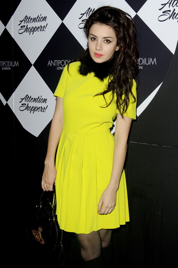 Kanári sárgában Vivienne Westwood kistáskával a londoni divathéten.