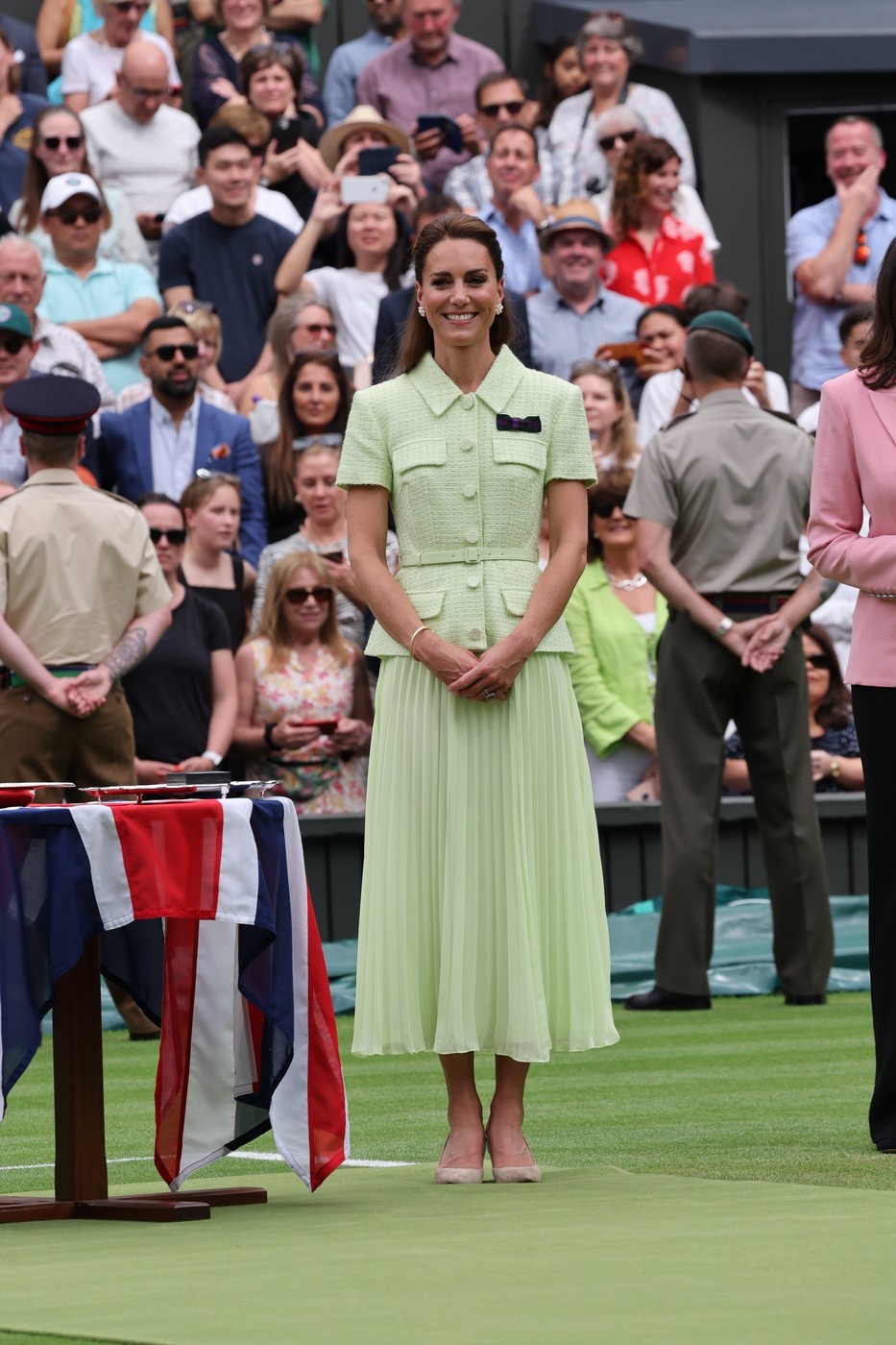 Katalin 2023-ban a teniszlabda színének egy világosabb árnyalatában is tündökölt. A szettje egy pliszírozott midi szoknyából és egy öves, rövid ujjú blézerből állt a Self-Portrait márkától. Az outfitet gyöngyös fülbevalókkal és nude magassarkúval koronázta meg.