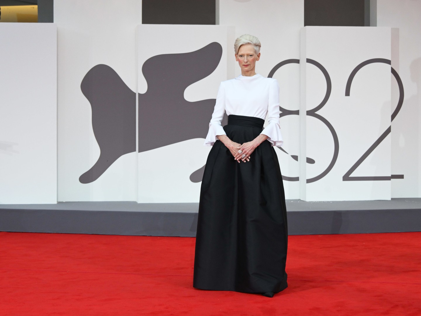 Tilda Swinton egy klasszikusan elegáns és nagyon kifinomult Chanel szettben pózolt a kameráknak: fehér, fodros ujjú blúzban és fekete mikádó selyem szoknyában ragyogott.  