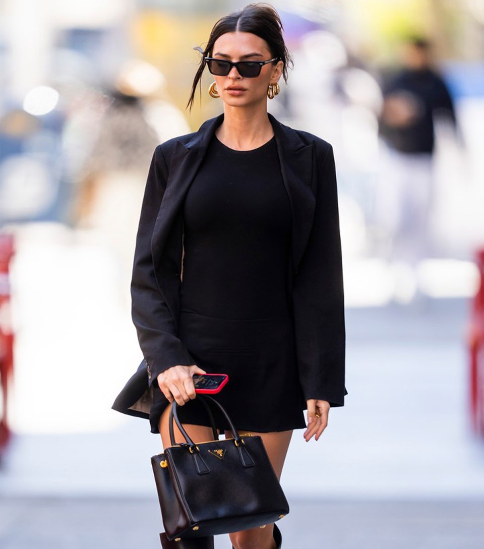 Emily Ratajkowski fekete szettjét az arany, vagy arany részleteket is tartalmazó kiegészítők csak még látványosabbá teszik