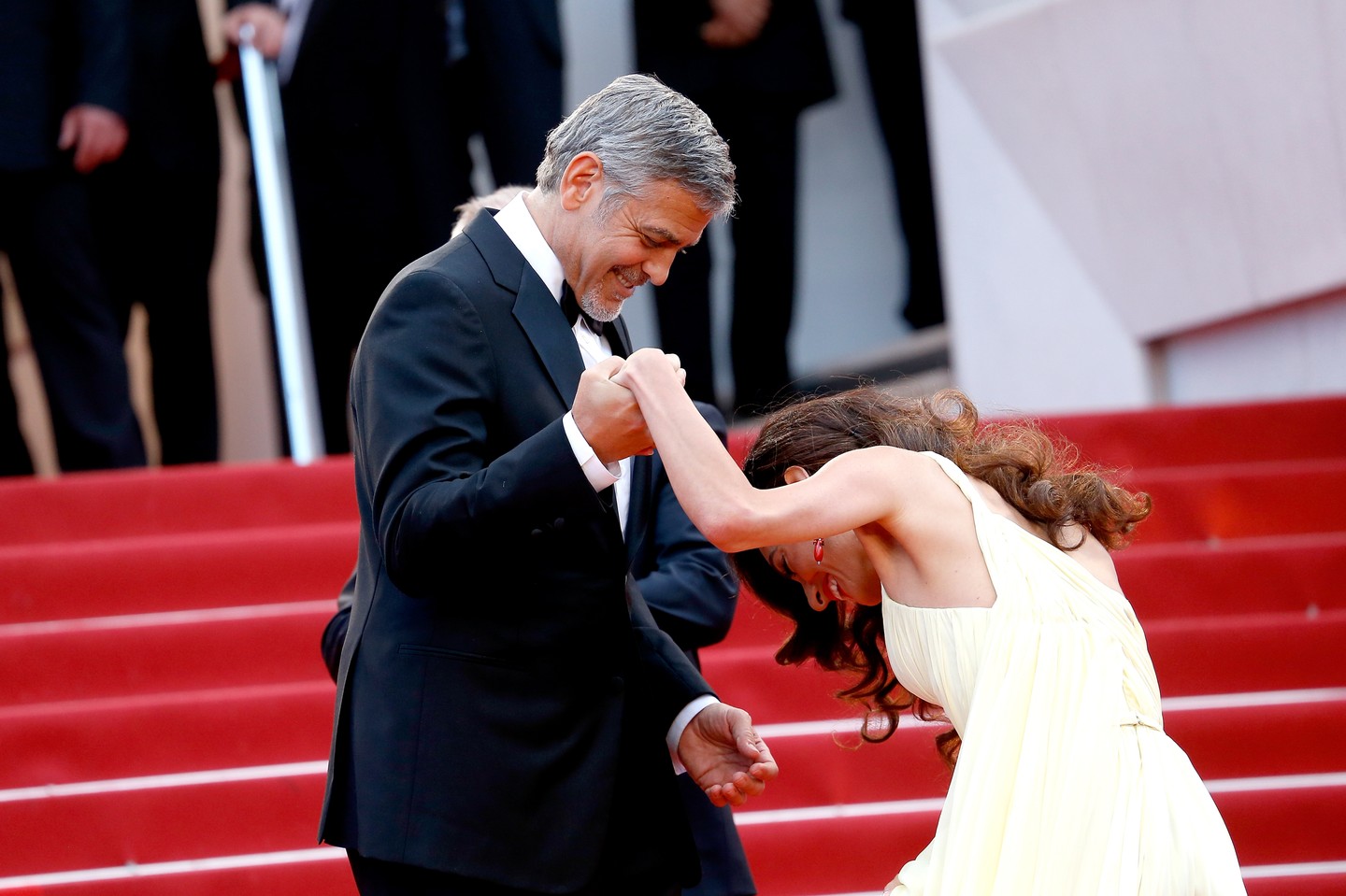 George Clooney igazi gavallér: ha kell, felesége, Amal Clooney ruháját is megigazgatja, hogy tökéletesen mutasson a fotókon. 