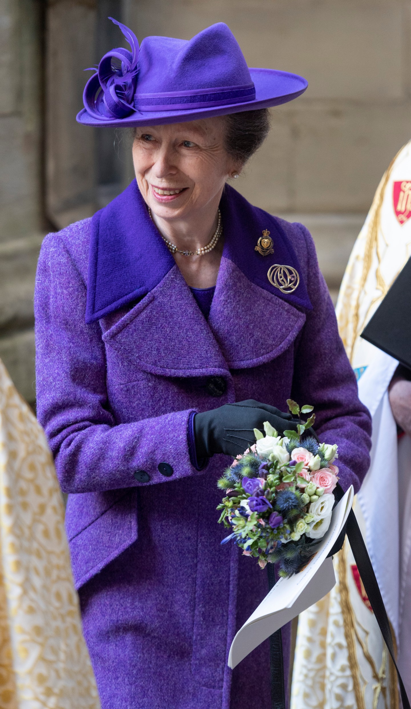 Károly király húga, Anna hercegnő 2021 októberében jelent meg ebben az elegáns szabású, széles gallérral és fekete gombokkal díszített lila gyapjú kabátban és hozzá illő kalapban. Kiegészítésképpen egy fekete bőrkesztyűt visel, amely szintén hozzájárul az összkép eleganciájához, és teljessé teszi a visszafogott, kifinomult stílust.