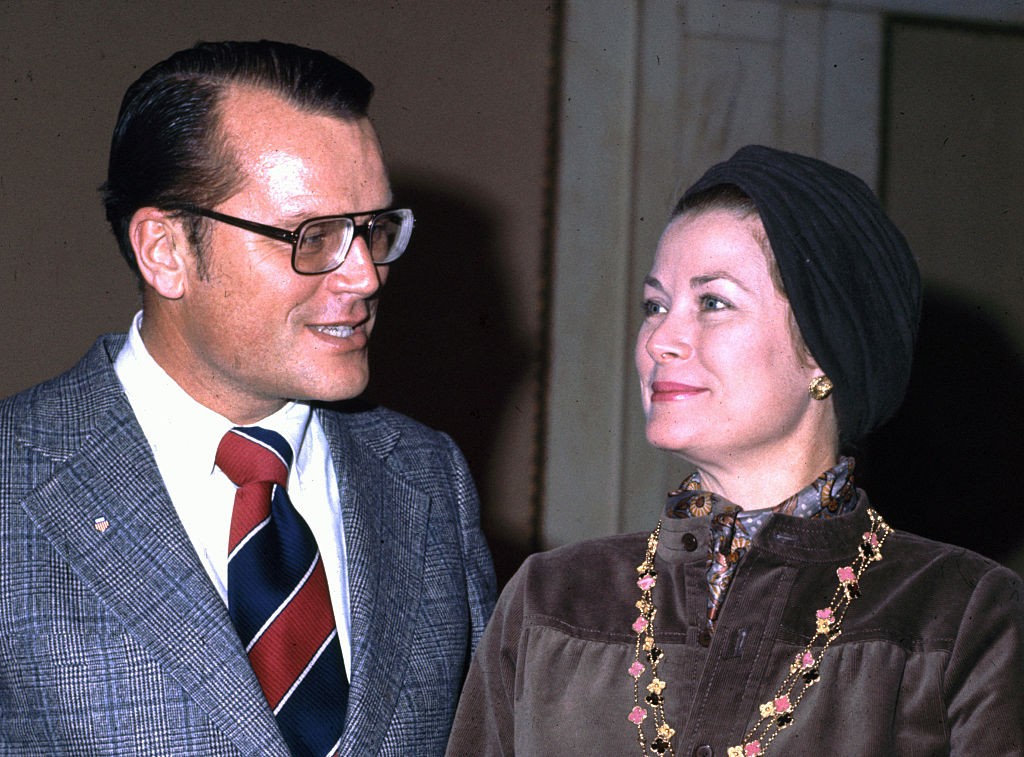 A felvétel 1980-ban készült a philadelphiai városházán, ahol Grace Kelly testvérét, Jack Kellyt látogatta meg. A hercegné visszafogott, barna ruhát és fejkendőt visel, nyakában egy hosszú, díszes lánccal. A két testvér egymás felé fordul, közvetlen beszélgetésük pillanatát örökítette meg ez a kép.