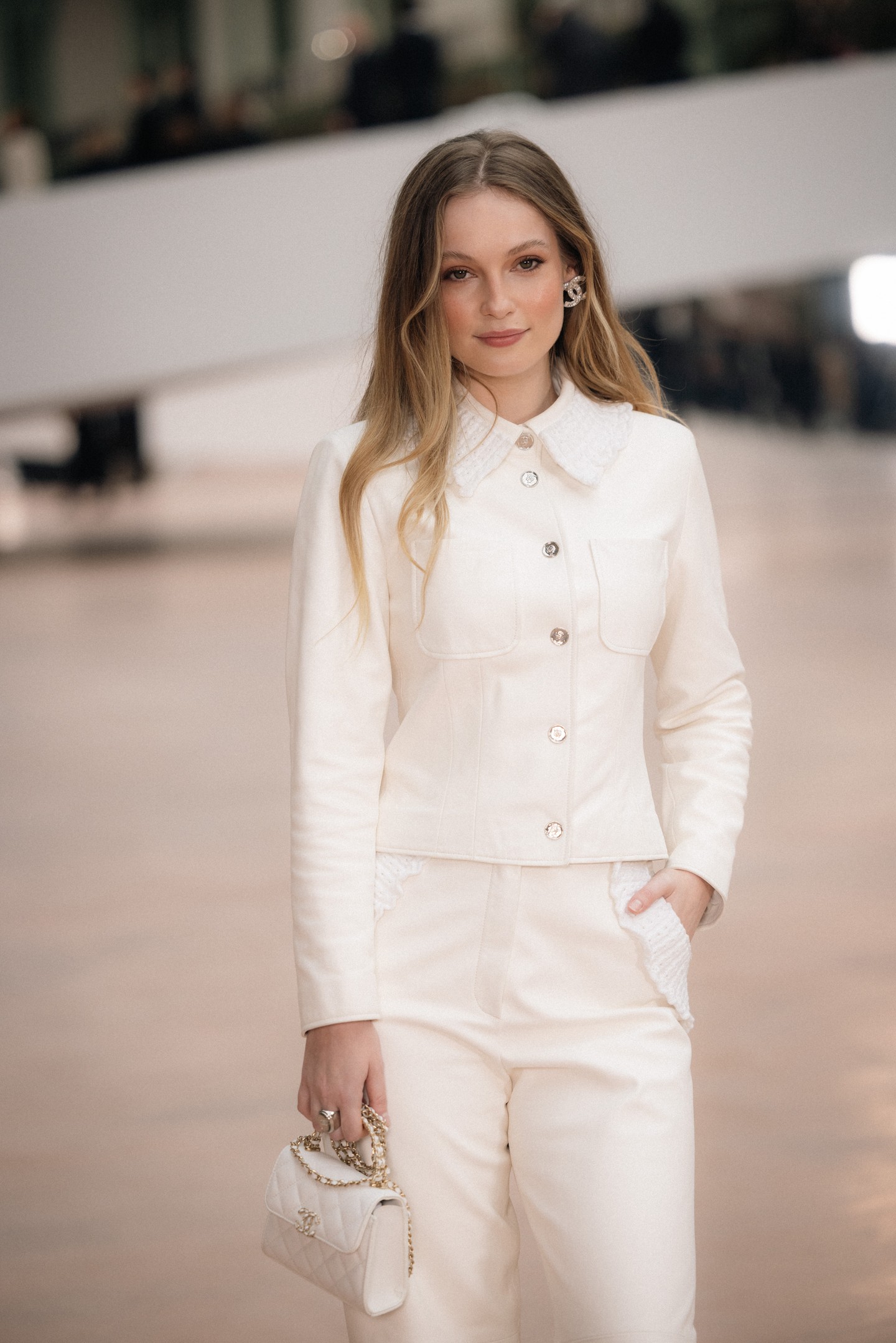 Hannah Dodd, A Bridgerton család sztárja tetőtől talpig hófehérben ragyogott: bőrkabátot és hozzáillő nadrágot viselt,  a szettjét pedig Chanel táskával és Chanel fülbevalókkal egészítette ki. 