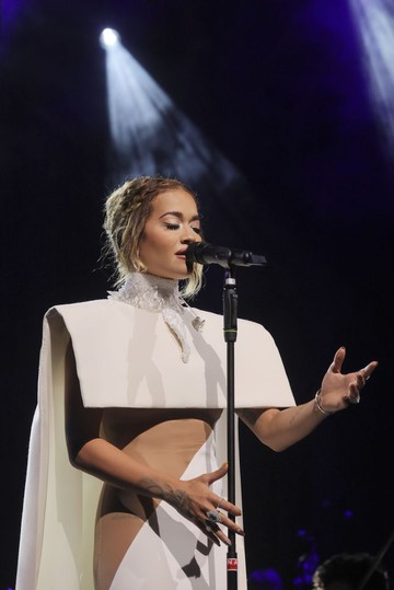 Rita Ora egy másik merész szettben lépett Olaszországban színpadra. A fehér ruha aszimmetrikus kivágása a mellei alsó vonalától a csípőéig tartott. 