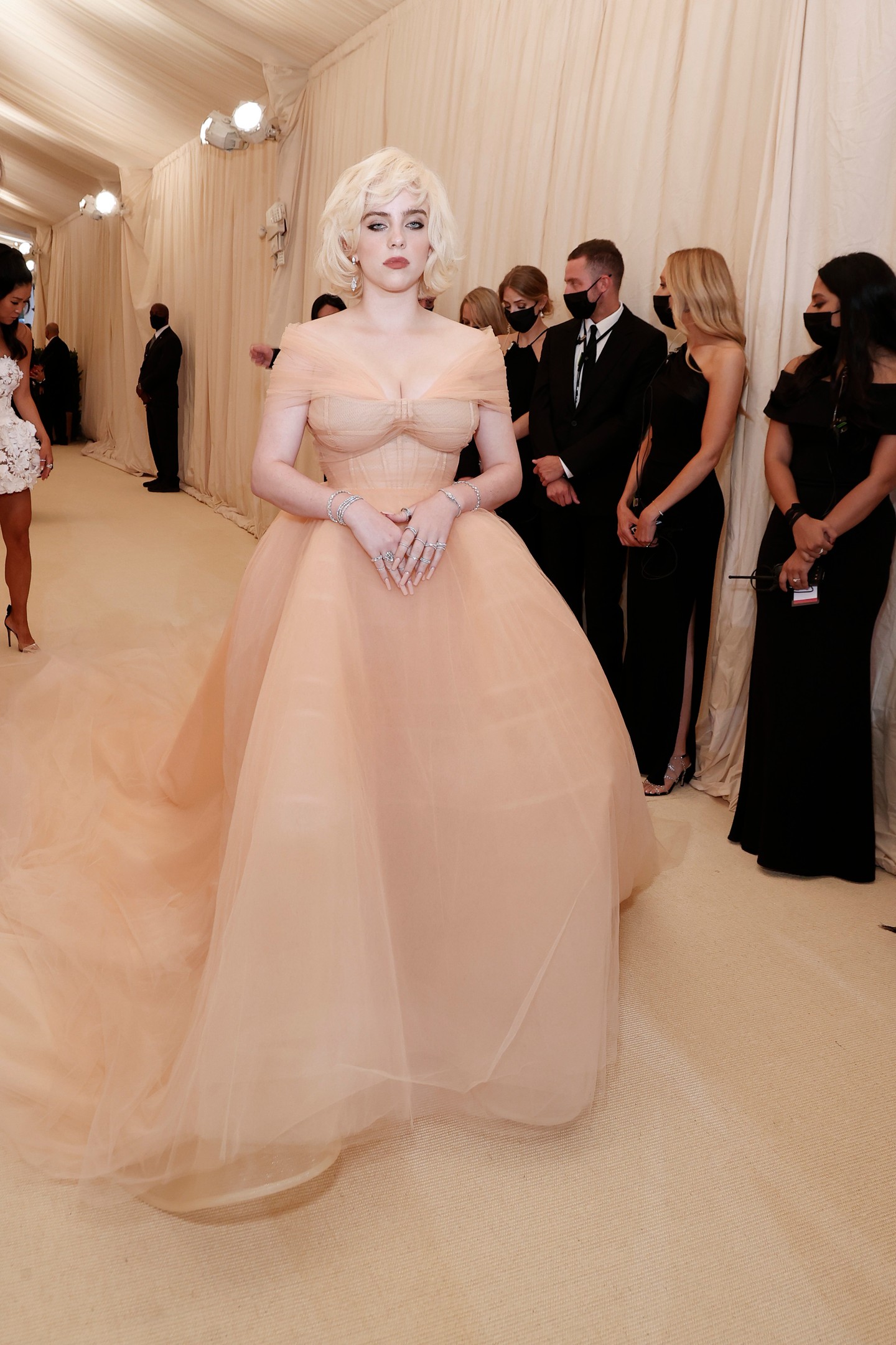 2021 Billie Eilish - Az énekesnő Marilyn Monroe ikonikus stílusát idézve egy Oscar de la Renta által tervezett, uszályos, barackszínű tüllruhában jelent meg a gálán. Fontos pillanat volt ez, mert Eilish csak azzal a feltétellel vállalta az együttműködést, hogy a divatház felhagy az állatszőrmék használatával.