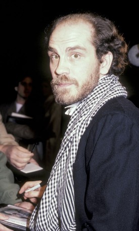 A lezser elegancia mestere (1985): John Malkovich sosem tartozott a tucatsztárok közé, és ezt a stílusával is rendszeresen bizonyította. Az Eleni című politikai dráma Los Angeles-i premierjén, a beverly hills-i Academy Theater előtt kapta lencsevégre a legendás fotós, Ron Galella. A színész a klasszikus eleganciát egy laza, kockás sállal dobta fel, miközben épp autogramot adott a rajongóknak – ez a fajta intellektuális, laza sárm pedig tökéletesen jellemezte őt karrierje legsikeresebb éveinek hajnalán.
