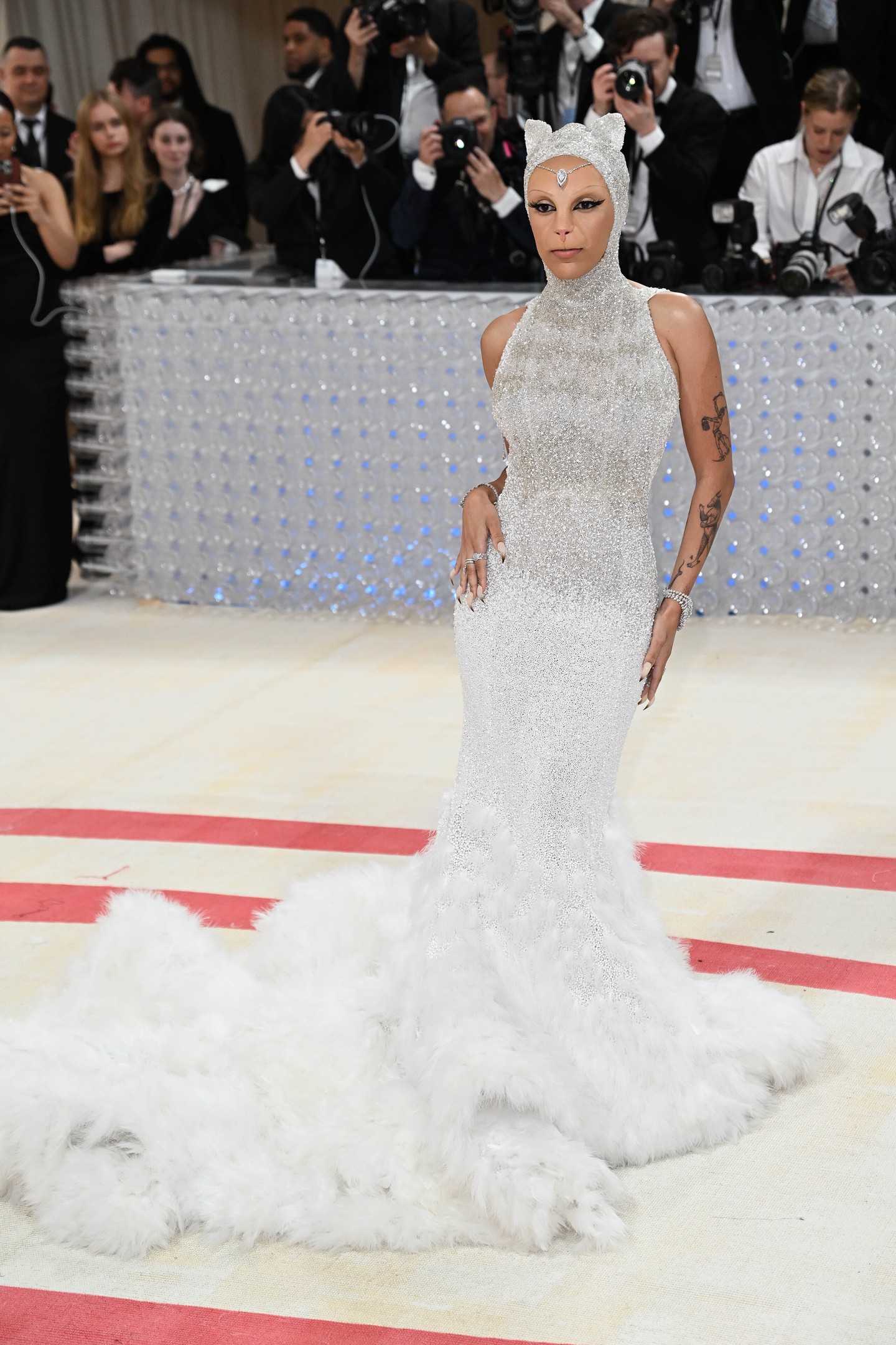 2023 Doja Cat - A rapper lenyűgöző, macskát idéző ruhája az Oscar de la Renta divatházból került ki, tisztelegve Karl Lagerfeld ikonikus macskája, Choupette előtt. A csillogó ezüst ruha egy macskamaszkkal egészült ki, ezzel is hangsúlyozva a gála „Karl Lagerfeld: A Line of Beauty” témáját. Doja Cat nem volt hajlandó megszólalni a vörös szőnyegen, csak nyávogott.