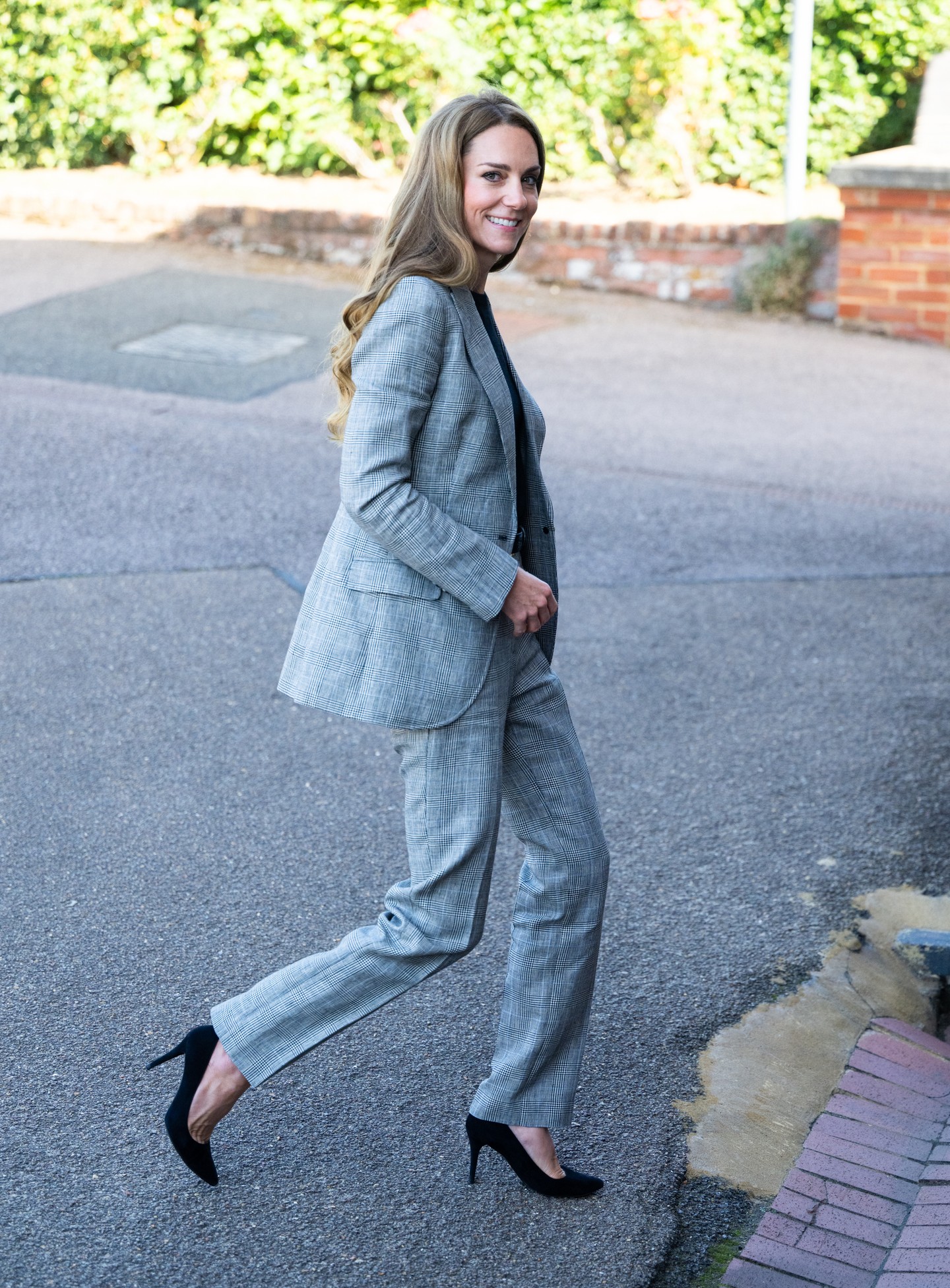 A business casual senkinek nem áll olyan jól, mint Katalin hercegnének. A képen látható fekete-fehér kockás nadrágkosztüm abszolút kimeríti a boss lady stílus definícióját. Bár Katalin gyakrabban választ szűkebb szabású nadrágokat, ezúttal egy bővebb fazonra voksolt, amely könnyedebbé tette az összhatást. A kosztümhöz egy fekete, vékony pulóvert, arany csattal díszített, vékony fekete bőrövet és fekete velúr magassarkút viselt. Ékszerként pedig egy apró fehér gyémántokkal díszített arany karika fülbevalót választott. 