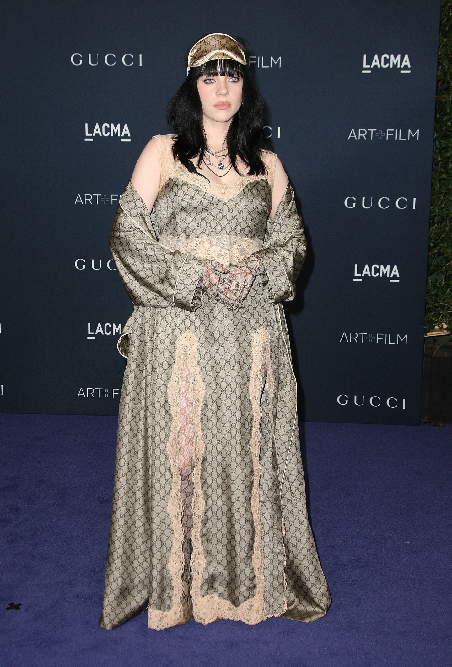 2022 - Gucci logó mindenhol, ám most a lezser szerelés egy nőiesebb hálóingre emlékeztető ruhára lett cserélve. És az egyik legviccesebb kiegészítője az összeállításnak egyértelműen az alvómaszk, mint hajdísz Billie Eilish fején.