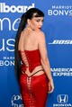 Katy Perry a 2024-es Billboard Women in Music díjátadón sem hazudtolta meg önmagát: egy merész, piros szatén fűzőben és egy hozzá illő szoknyában érkezett a vörös szőnyegre, amelyet hátul – egészen a fenekéig – fűzős pántok tartottak össze. A különleges szett tervezője Ellie Misner, aki a fűzőt a klasszikus pin-up stílus és a modern „butt reveal” trend keresztezéseként álmodta meg.