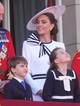 Katalin hercegné idén először a Trooping the Color ünnepségen jelent meg nyilvánosan, ahol azt a Jenny Packham ruhát viselte, amit korábban már láthattunk rajta. Igaz, a parádéra kicsit átalakíttatta a szettjét - a derekán lévő övet a sima feketéről csíkosra cserélte, valamint egy hatalmas, csíkos masni is került a felső részére.