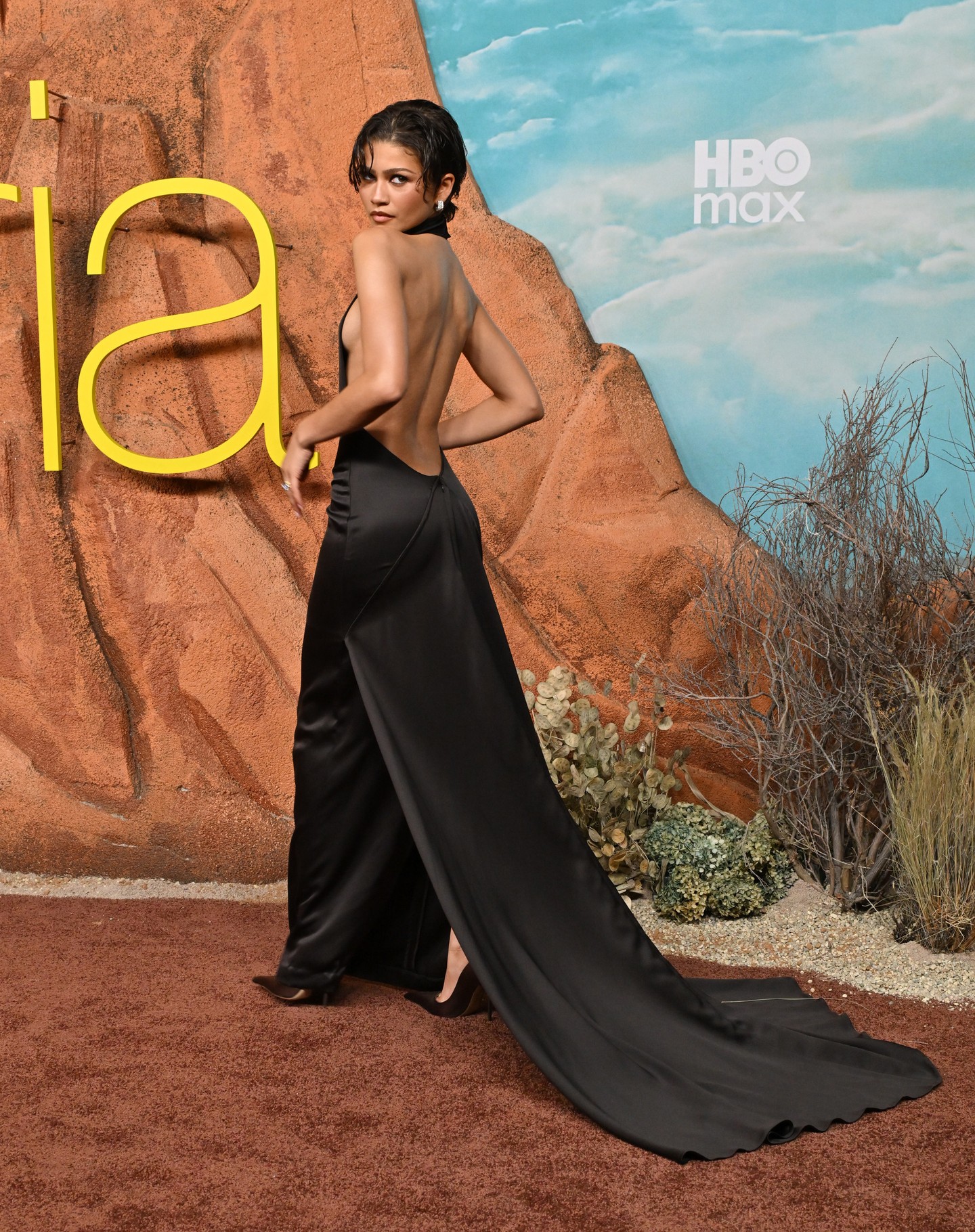 Az Ashi Studio által tervezett, nyakpántos estélyi különlegessége a hátul nyitott kialakítás és az oldalsó kivágások, amelyek látványosan szabadon hagyják a színésznő hátát. 