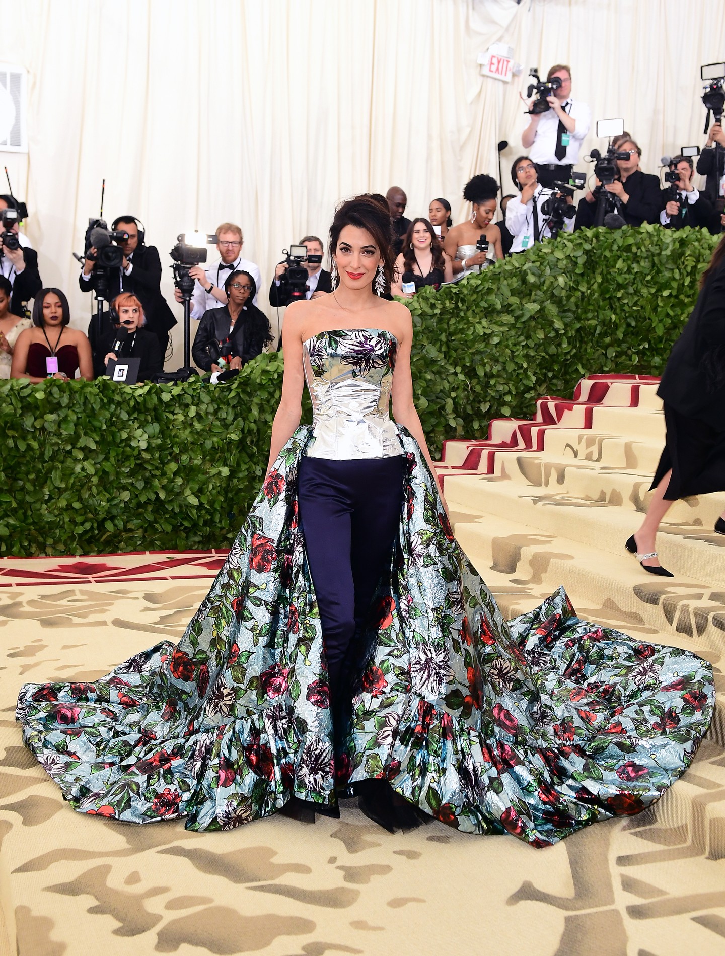 2018 - Anna Wintour is megkedvelte Amal Clooney-t, és felajánlotta az áhított társelnöki pozíciót a 2018-as Met-gálára, a Vogue májusi számának borítójával együtt. Amal az eseményen egy virágos Richard Quinn tervezésben tért vissza a MET lépcsőjére.