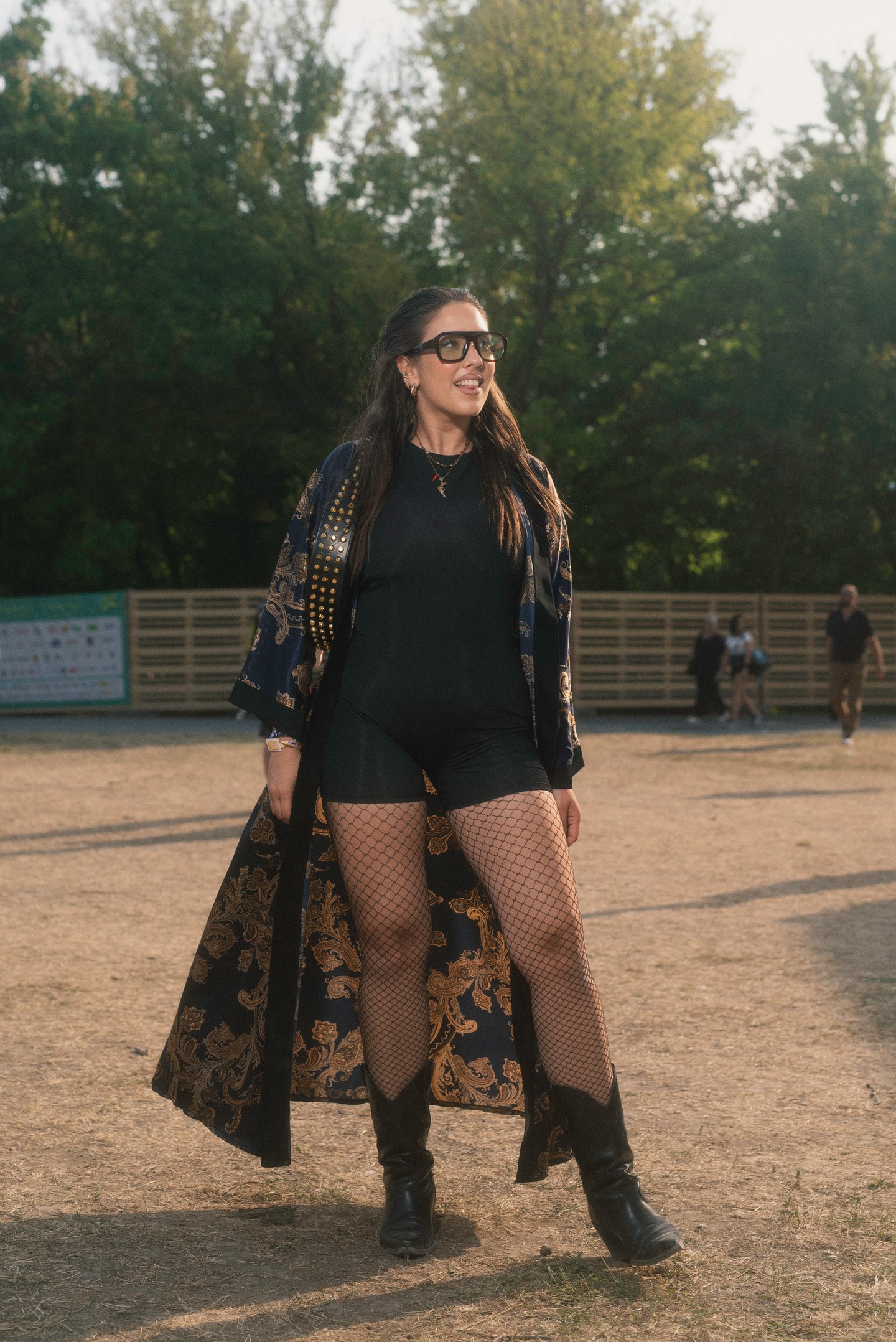 Ez a szett igazi drámai belépőt garantál: a hosszú, aranymintás köpeny és a hálós harisnya azonnal magára vonja a tekintetet. A fekete összeállítás és a vagány csizmák tökéletes alapot teremtenek, hogy a kiegészítők és a különböző textúrák érvényesülhessenek. A hatás egyszerre rockos, bohém és egy leheletnyit misztikus.