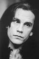Londoni lázban (1986): John Malkovich 33 évesen, dús, sötét fürtökkel és elképesztően intenzív tekintettel babonázta meg a brit közönséget. A fotó a londoni Hampstead Theatre-ben készült a Circe & Bravo című színdarab bemutatója idején, ahol a színész nyers, szuggesztív játéka és lázadó sármja azonnal bebizonyította, hogy nemcsak a kamerák előtt, hanem a színpadon is született szívtipró.